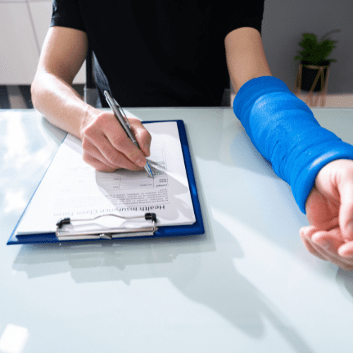 injured person filling out a paper form with a pen